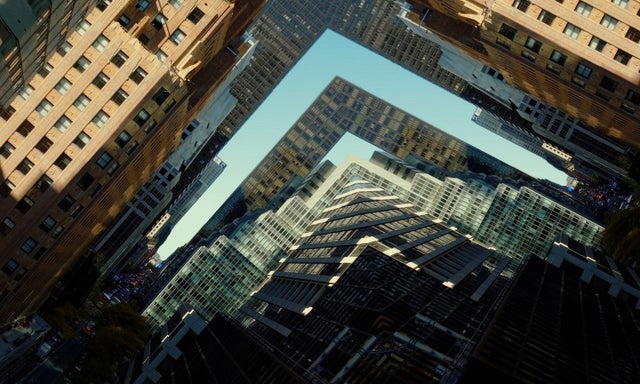 Aerial view of high-rise buildings forming an L-shaped gap and sharp skyline, highlighting urban density and geometry.​